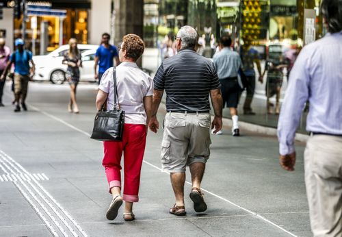 Two old people walk down the street in Brisbane