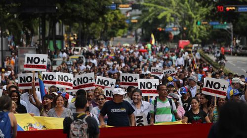 Demonstrators march to support the self-proclaimed President Juan Guaido, in Caracas.