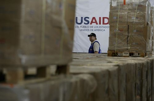 A man walks past boxes of USAID humanitarian aid at a warehouse at the Tienditas International Bridge on the outskirts of Cucuta, Colombia, Feb. 21, 2019.