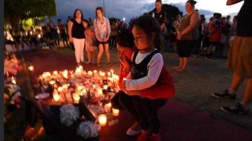 Mourners attend a candlelight vigil outside Dreamworld last October.