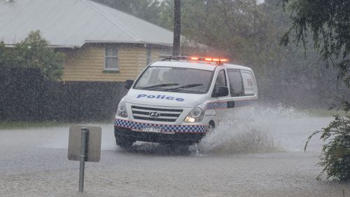 A police car drives through floodwaters in South Townsville. 