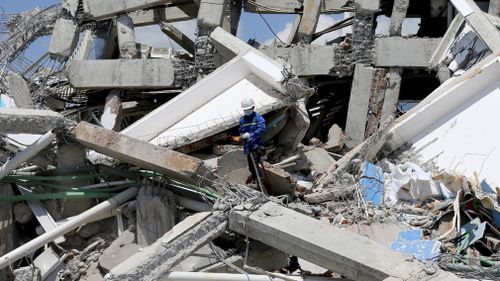 A worker searching the Roa-Roa Hotel for victims. 