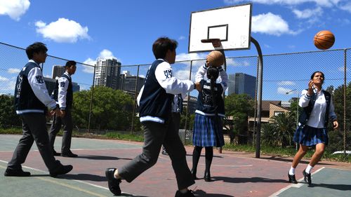 Parramatta High School year 12 students play basketball on the school grounds.