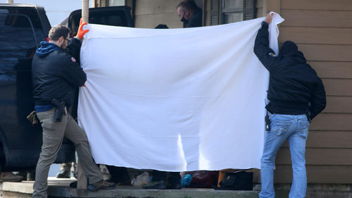 Investigators block the public's view as bodies are removed from the scene of a suspected mass homicide where at least 5 children were slain Tuesday, February 2.