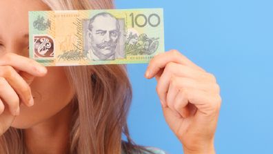 Woman holding Australian $100 note 