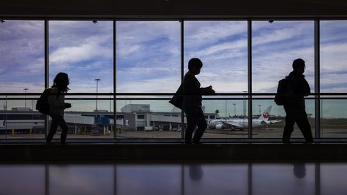 SYDNEY, AUSTRALIA - 23 GIUGNO: I viaggiatori vengono visti all'aeroporto internazionale di Sydney il 23 giugno 2021 a Sydney, Australia. Sydney registra 16 nuovi casi di COVID-19 acquisiti localmente poiché le nuove rigide restrizioni sul distanziamento sociale entrano in vigore alle 16:00 di oggi. Le mascherine sono ora obbligatorie in tutti gli ambienti interni non residenziali, compresi i luoghi di lavoro. Non è consentito firmare o ballare nei locali, lezioni di ballo e di palestra con un massimo di 20 persone alla volta e non più di cinque visitatori per famiglia, incluso