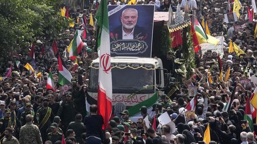 Iranians follow a truck, center, carrying the coffins of Hamas leader Ismail Haniyeh and his bodyguard who were killed in an assassination blamed on Israel on Wednesday, during their funeral ceremony at Enqelab-e-Eslami (Islamic Revolution) Sq. in Tehran, Iran, Thursday, Aug. 1, 2024. (AP Photo/Vahid Salemi)