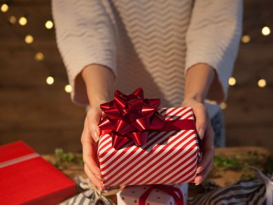 Woman holding wrapped Christmas present 1