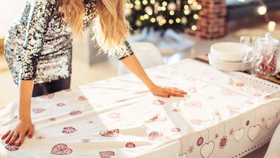 Woman arranging table for Christmas dinner. 