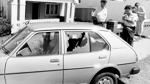 A policemen stands guard over the with Consuler Corps license plates which was being driven by the bodyguard.  December 17, 1980.