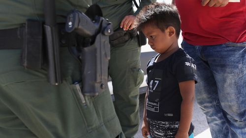 A boy and father from Honduras are taken into custody by US Border Patrol agents near the US-Mexico Border on June 12, 2018 near Mission, Texas.