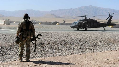 An Australian Special Operations Task Group Soldier waits to move towards a UH-60 Blackhawk helicopter as part of the Shah Wali Kot Offensive.