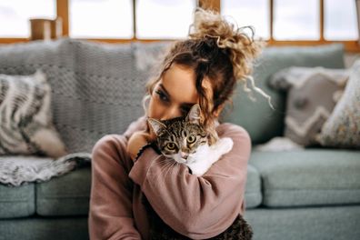 Cat stock Young woman bonding with her cat in apartment
