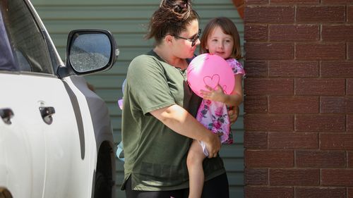 Cleo Smith is carried inside a friend's house by her mother in Carnarvon.