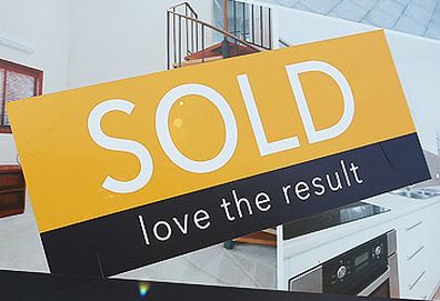 Sold sticker on real estate signboard (Getty)