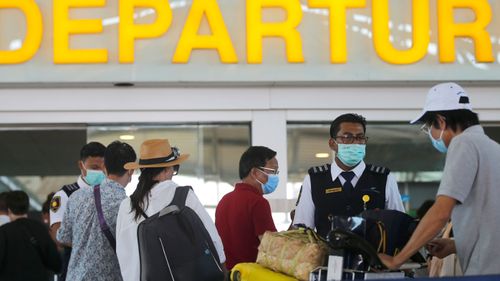 Tourists line up at a departure gate at Bali airport, Indonesia.