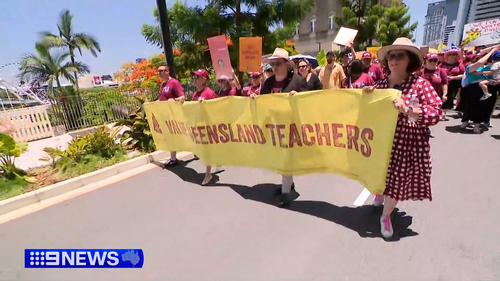 Greve katılan üyeler, hükümeti öğretmenlere değer vermeye çağıran bir pankart tutuyor.