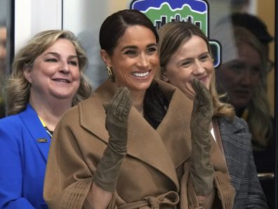Meghan, Duchess of Sussex, raises her hands after a First Nations welcome during an Invictus Games wheelchair curling training camp in Vancouver, British Columbia, Friday, Feb. 16, 2024. (Darryl Dyck/The Canadian Press via AP)