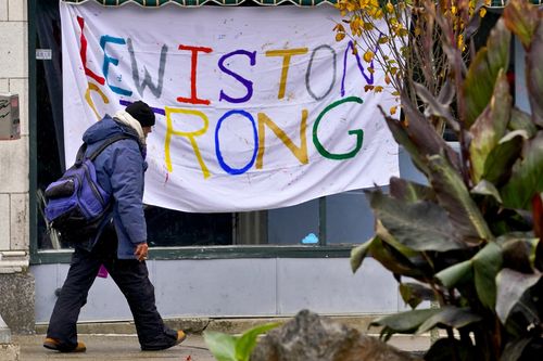 A man walks past a "Lewiston Strong" sign, Sunday, Oct. 29, 2023, in Lewiston, Maine.