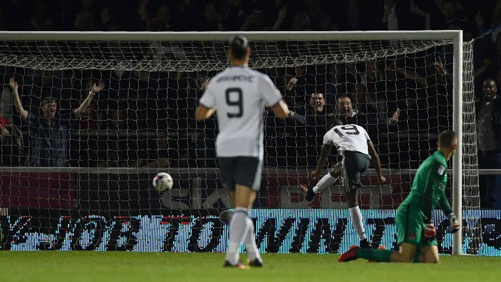 Manchester United's Marcus Ashford scores his side's third goal in the third round League Cup match against Northampton Town.(AFP)