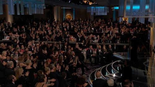 The Golden Globes audience gives Oprah a standing ovation.