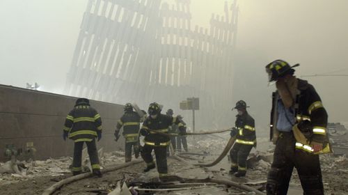 Firefighters work beneath the destroyed mullions, the vertical struts which once faced the soaring outer walls of the World Trade Center towers. (AAP)