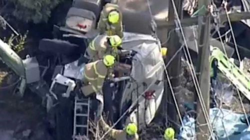 Chopper vision shows fire crews pulling the driver to safety. (9NEWS)