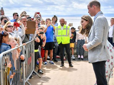 Britain's Prince William and Kate, the Duchess of Cambridge talk with members of the public in Barry Island, Wales, Wednesday Aug. 5, 2020, during their visit to speak to local business owners about the impact of COVID-19.
