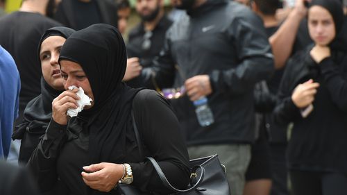 Tearful mourners leave a packed mosque. (AAP)