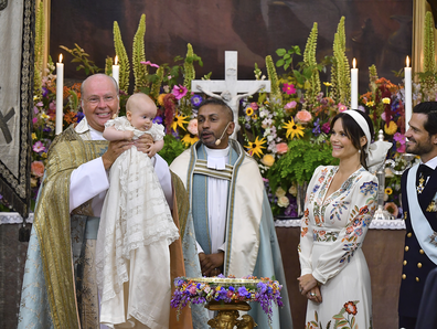 Bishop Johan Dalman, left, holds Prince Julian, as Reverend Michael Bjerkhagen, centre, Princess Sofia, seond right and Prince Carl Philip look on, at the Drottningholm Palace Chapel, in Stockholm, Sweden, Saturday, Aug. 14, 2021