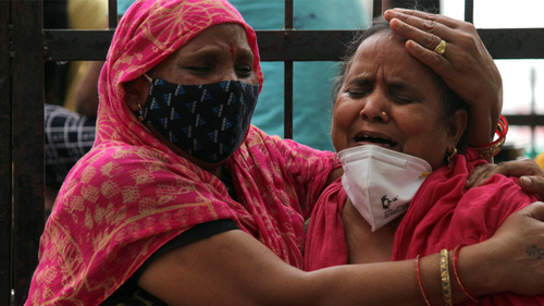 Women mourn the death of a family member, who died due to the coronavirus disease (COVID-19), outside the Lok Nayak Jai Prakash Narayan Hospital (LNJP), one of the largest facilities for coronavirus disease  patients, in New Delhi, India on May 4, 2021. (Photo by Mayank Makhija/NurPhoto via Getty Images)