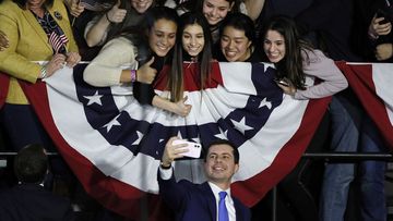 Pete Buttigieg takes a selfie with supporters at his election night rally in Iowa.