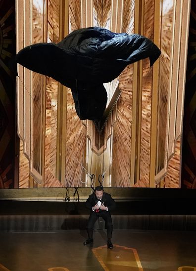 Host Jimmy Kimmel drops onto stage by parachute at the Oscars on Sunday, March 12, 2023, at the Dolby Theatre in Los Angeles. (AP Photo/Chris Pizzello)