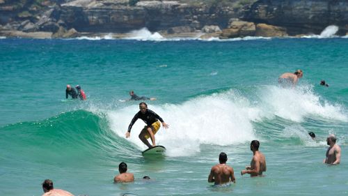 Many sought respite from yesterday's blistering heat by hitting the beach. (AAP)