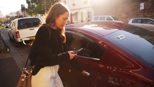 A woman using the Ola rideshare app.