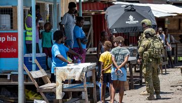 Australian Army soldiers talk with local citizens in Honiara, Solomon Islands