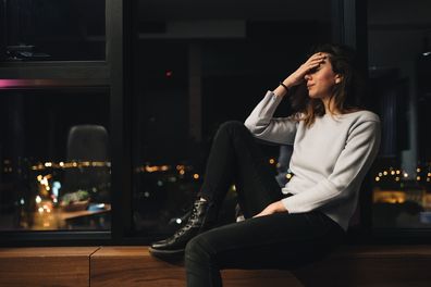 Abused young woman sitting in her room alone crying after being abused