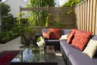 A modern patio with an outdoor wicker sofa.