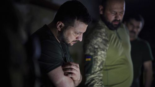 In this photo provided by the Ukrainian Presidential Press Office, Ukrainian President Volodymyr Zelenskyy, left, listens to a servicemen report close to the front line in Donetsk region, Ukraine, Sunday, June 5, 2022. (Ukrainian Presidential Press Office via AP)