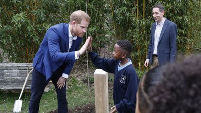 Duke of Sussex high fives with Asher Charles-Bowen after planting a tree from the Woodland Trust at St Vincent's Catholic Primary School. 