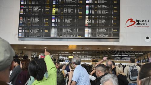 Um funcionário do aeroporto aponta em um conselho de partida depois que um ataque cibernético causou atrasos no Aeroporto Internacional de Bruxelas em Zaventem, Bélgica, sábado, 20 de setembro de 2025. (AP Photo/Harry Nakos)