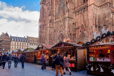 People stroll among the stalls at the Christmas market in Place de la Cathédrale in Strasbourg, France. 