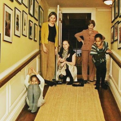 Malia and Sasha Obama slide down the White House banisters as Jenna, Barbara and Laura Bush look on.