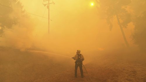 Um bombeiro de batalhas de bombeiros em Hasley Canyon, Califórnia
