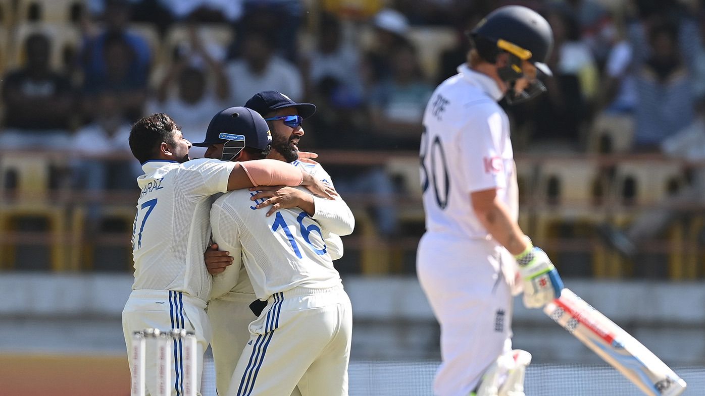 India wicketkeeper Dhruv Jurel and captain Rohit Sharma celebrate with Kuldeep Yadav after Sharma had caught out England batsman Ollie Pope during day four of the 3rd Test Match between India  and England at Saurashtra Cricket Association Stadium on February 18, 2024 in Rajkot, India. (Photo by Gareth Copley/Getty Images)