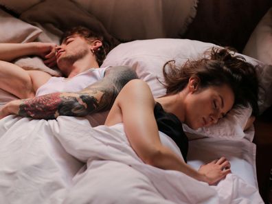 Stock photo of a woman and man in bed together.