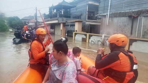 Rescuers evacuate residents from their flooded home in Denpasar, Bali.