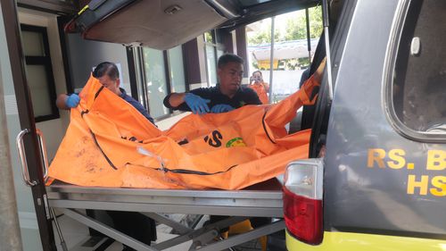 Rescuers remove the newly-recovered body of a victim of a building that collapsed at an Islamic boarding school from an ambulance upon arrival at the police hospital in Surabaya, East Java, Indonesia, Sunday, Oct. 5, 2025. (AP Photo/Trisnadi)