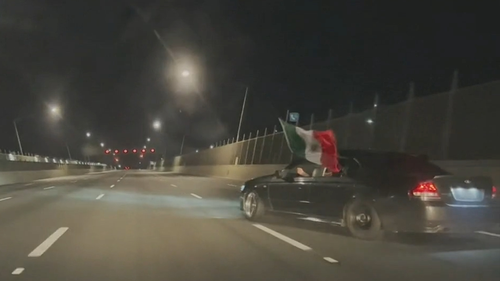 The reckless driving, caught on camera by a notorious Gold Coast hoon gang, shows the drivers swerving across several lanes on the Gateway Bridge in Brisbane's east, bearing a Mexican flag.