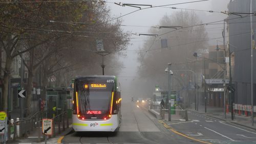 Le brouillard est visible au-dessus de l'extrémité supérieure d'une rue Bourke presque vide le 17 juillet 2020 à Melbourne, en Australie.